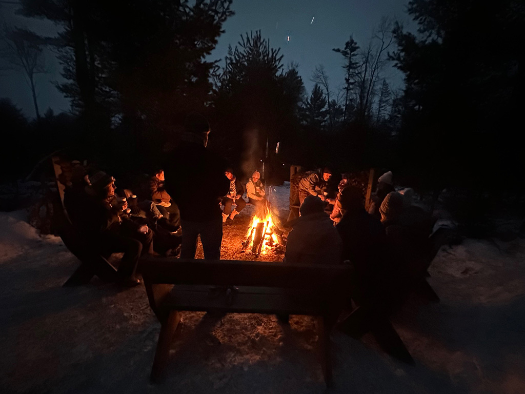 Guests around the fire with hot chocolate